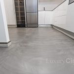 suelo de cocina revestido de microcemento gris a juego con muebles bancos