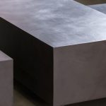 detalle de mesa baja de microcemento con taburetes cubos